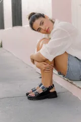 Sandalias de plataforma estilo chunky en color negro, confeccionadas en material sintético efecto charol. Presentan dos tiras ajustables con hebillas metálicas plateadas y una tira trasera con hebilla para mayor sujeción. Suela dentada de goma.