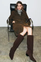 Bota de caña alta confeccionada en serraje, con diseño estilo cowboy, acabado en punta y tacón kitten en bloque.