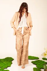 Pantalón de satén color beige con estampado floral, corte palazzo y cintura elastizada.