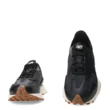 Championes urbanos New Balance modelo 327, color negro con entresuela blanca y suela de goma color caramelo. Presentan un diseño retro con el logo N característico en el lateral y una estructura de cuero sintético.