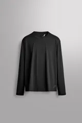 Camiseta de entrenamiento de manga larga y cuello redondo, color negro, confeccionada en tejido técnico elástico de secado rápido con detalle de logo estampado en el bajo.