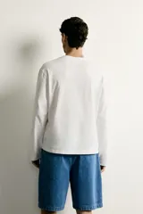 Remera manga larga de corte regular, color azul marino, con cuello redondo y un bolsillo aplicado en el pecho.