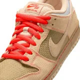 Championes Nike SB Dunk Low Pro Som Tum en tonos beige y tostado, con paneles de lona y gamuza texturizada, cordones rojos y detalles plateados en el talón.