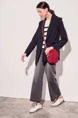 Blazer negro de corte clásico con solapas y mangas largas con puños con rayas verticales.