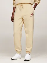 Pantalón de jogging color crema, de corte cónico, con cintura elástica ajustable con cordón, bolsillos laterales y logo bordado en la pierna.