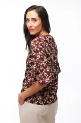 Blusa marrón con estampado floral blanco, de mangas cortas acampanadas y corte holgado.