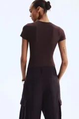 Body de manga corta color marrón oscuro, con escote redondo y corte alto en la entrepierna.