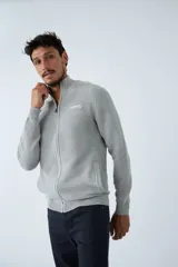 Campera tejida de algodón con textura acanalada, cierre frontal completo, cuello alto y bolsillos laterales. Presenta logo de la marca bordado en el pecho.