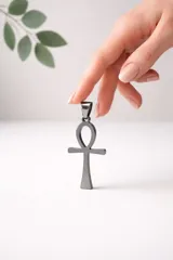 Dije con forma de cruz egipcia (Ankh) fabricado en acero inoxidable de acabado pulido oscuro.