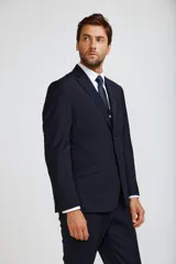 Traje completo de tres piezas en color azul marino, compuesto por saco entallado, chaleco abotonado y pantalón de vestir de corte recto.