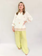 Blusa blanca de manga 3/4 con bordados en hilo verde oliva, cuello mao con abertura y botones, y terminación bordada en el ruedo y puños.