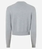 Cardigan corto de punto color gris, con cuello redondo, mangas largas y cierre frontal con botones. Presenta un diseño ajustado al cuerpo con bordados de cerezas distribuidos por toda la prenda.