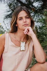 Collar rígido dorado con dije rectangular de guampa clara con engarce de alpaca.