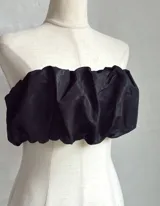 Top bandeau negro con textura fruncida y estampado abstracto plateado.