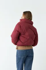 Campera puffer color borgoña de nylon con cuello alto, cierre frontal y bolsillos laterales.