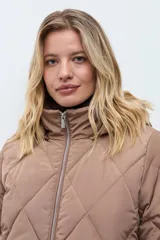 Campera acolchada de corte largo con diseño capitoneado en forma de rombos, cierre frontal con cremallera y capucha integrada.