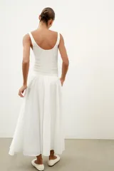 Top de punto canalé en color beige, con escote en pico adornado con una delicada aplicación de encaje blanco y tirantes anchos.