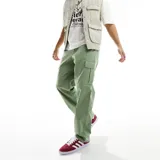 Pantalón cargo verde de corte holgado, con bolsillos laterales y logo de Nike bordado en la pierna izquierda.