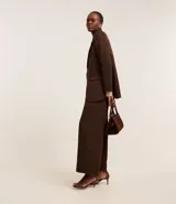 Blusa de punto leve color beige, con cuello degagê, mangas largas y fruncido lateral.