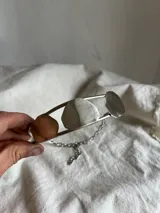 Gargantilla doble plateada con cadena de eslabones y tres piezas irregulares: una color cobre, una plateada y una gris.