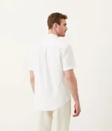 Camisa de hombre de manga corta confeccionada en mezcla de lino y algodón. Presenta un calce comfort, cuello camisero, cierre frontal con botones y un bolsillo en el pecho. Marca Marfinno.