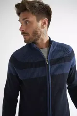 Campera tejida de algodón con diseño color block en tonos beige y marrón. Presenta cierre frontal completo, cuello alto y textura acanalada.