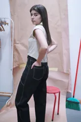 Pantalón negro de corte recto con costuras blancas contrastantes y detalle de cordones cruzados en la cintura.