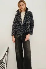 Tapado corto de corte sastre con solapas amplias y cierre frontal cruzado de doble botonadura. Presenta un estampado animal print en tonos grises y negros, con textura suave y mangas largas.