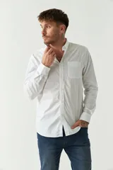 Camisa blanca de manga larga con fit regular, logo bordado y bolsillo tipo cartera. Confeccionada en algodón.