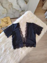 Top negro de lycra con mangas cortas de encaje, escote en V con borde de encaje y espalda de microtul con detalles de encaje.