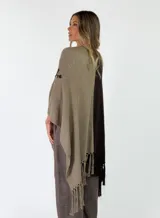 Ruana de punto bicolor, con un lado marrón y otro lado beige con detalle de bordado floral y flecos en los bordes inferiores.