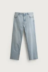 Jeans de corte recto color celeste claro, con tiro medio, diseño de cinco bolsillos, efecto lavado y bajo con acabado irregular deshilachado.