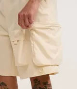 Bermuda masculina de poliéster color negro, corte baggy cropped, con cintura elástica ajustable con cordón y bolsillos funcionales.