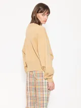 Buzo negro de punto con calce amplio y largo a la altura de la primera cadera. Tiene mangas largas, cuello redondo y estampa frontal con strass hotfix y logo bordado en la espalda.