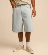 Bermuda baggy de jean color negro con pespuntes contrastantes, cierre de botón y cremallera, y bolsillos.