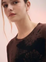 Remera marrón con estampado abstracto en negro, de corte holgado y mangas 3/4.