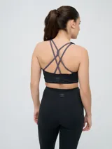 Top deportivo Umbro color negro con diseño de espalda nadadora y banda elástica en la base para mayor soporte.
