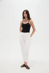 Pantalón jean de tiro alto y corte recto, color blanco, con bolsillos laterales y traseros, y terminación desmechada en los tobillos.