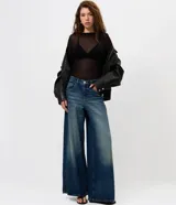 Blusa de manga larga con transparencia, confeccionada en viscosa y elastano. Presenta un diseño ajustado al cuerpo, cuello redondo y textura sutil, ideal para usar en capas.