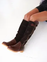 Botas altas de gamuza color marrón oscuro combinadas con cuero color marrón claro, forradas en cuero y con cierre lateral de bronce.