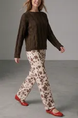 Sweater de punto color chocolate con diseño de trenzas verticales, cuello redondo y manga larga.