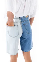 Bermuda de jean de tiro alto, con una pierna en color celeste y otra en azul.