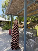 Vestido largo con estampado de zigzag en tonos beige y negro, con cuello halter y espalda descubierta.