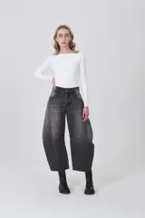Pantalon de jean estilo barrel con efecto lavado, de tiro medio, con bolsillos laterales y traseros, y costuras decorativas en las rodillas.