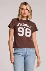 Remera marrón con estampado frontal en color blanco con la inscripción 'J'adore 98' de estilo universitario.