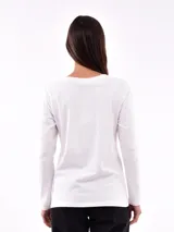 Remera negra de manga larga con cuello redondo y detalle de tachas doradas dispuestas en diagonal sobre el pecho.