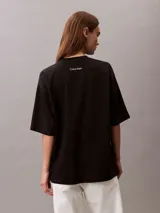 Remera de corte oversize confeccionada en algodón, con cuello redondo y mangas cortas. Presenta un estampado frontal con el logo de la marca en disposición vertical.