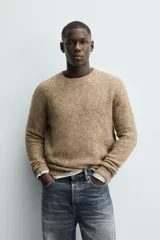 Jersey de punto regular fit, confeccionado en una mezcla de lana y fibra de alpaca. Presenta cuello redondo, manga larga y acabados en rib en puños y bajo.