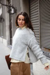 Buzo tejido en mohair de corte crop, con cuello redondo y tajos laterales. Diseño holgado con mangas largas.