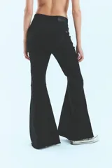 Pantalón jean negro de tiro medio alto y corte oxford con botamanga ancha al corte.